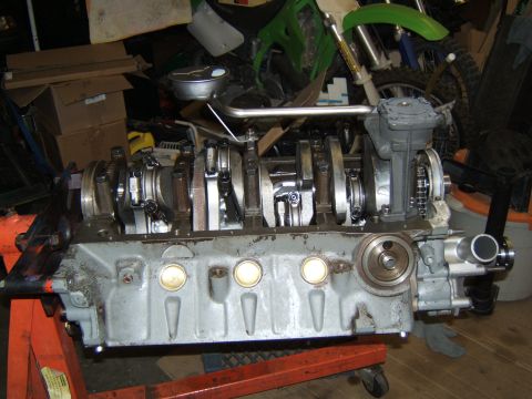 1988 Ford Bronco - Engine block assembly with crankshaft and connecting rods visible, set up on an engine stand in a garage.