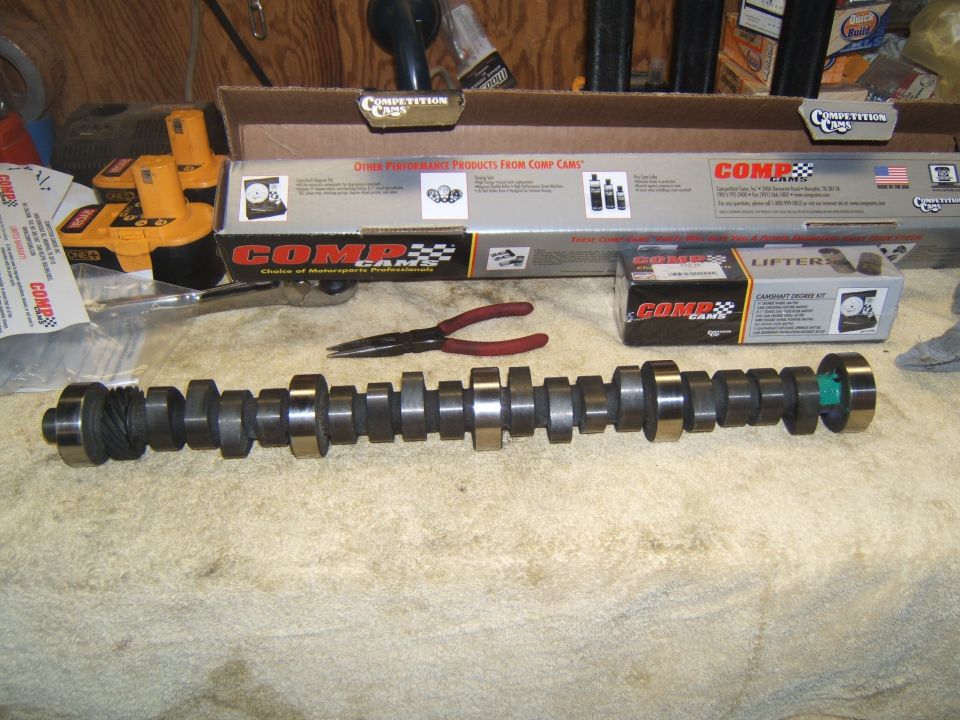 Camshaft, lifter kit box, and Comp Cams packaging on a workbench