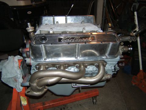 1988 Ford Bronco - Engine with chrome Edelbrock valve covers and exhaust headers on an orange engine stand.