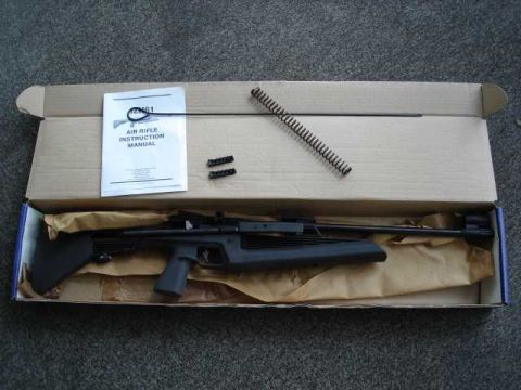 1984 Ford Bronco - An air rifle, its instruction manual, and components are laid out inside a cardboard box.