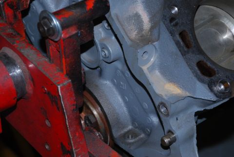 1996 Ford Bronco - Close-up of an engine block with a red metal bracket attached.