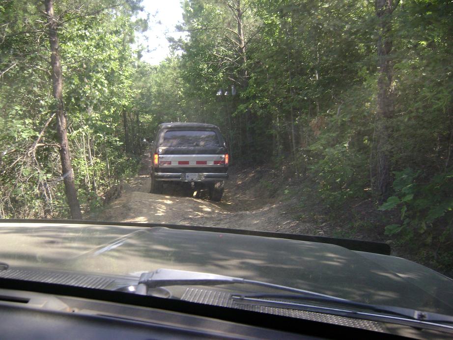 Driving behind a 1990 Ford Bronco on a wooded dirt road