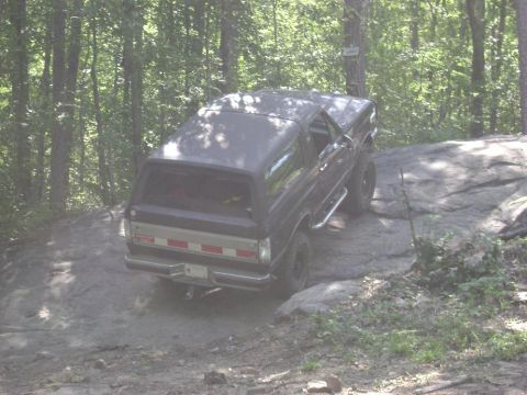 1990 Ford Bronco - This 1990 Ford Bronco navigates a challenging off-road course through a forest.