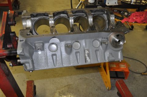 1996 Ford Bronco - A disassembled engine block is mounted on a stand in a workshop setting.