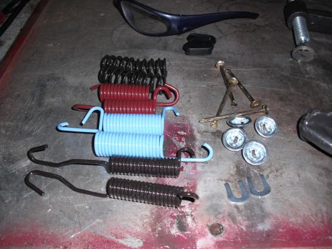 1991 Ford Bronco - A collection of brake springs and hardware laid out on a workbench, ready for installation or repair.