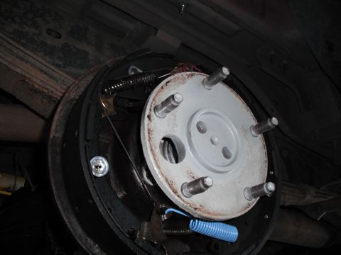 1991 Ford Bronco - Close-up view of a vehicle's drum brake assembly, showing the brake shoes, springs, and hub.