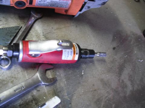 1991 Ford Bronco - Tools including an angle grinder and wrenches are laid out on a workbench.