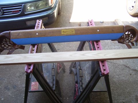 1991 Ford Bronco - A pool table rail, possibly being repaired or restored, is supported by sawhorses in front of a car.