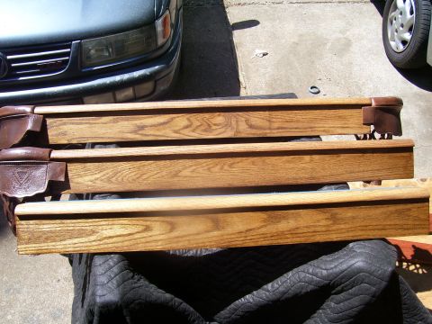 1991 Ford Bronco - Wooden pool table rails are laid out on a protective cover, with a car visible in the background.
