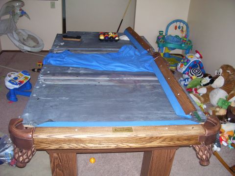 1991 Ford Bronco - A pool table is set up in a room with toys and stuffed animals.