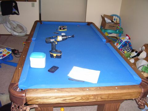 1991 Ford Bronco - A cordless drill and other items are placed on a blue felt pool table.