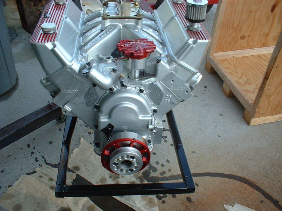 Silver V8 engine on a stand, with red distributor cap and air filter