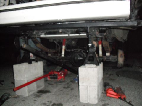 1991 Ford Bronco - Undercarriage of a 1991 Ford Bronco being serviced, elevated on jack stands.