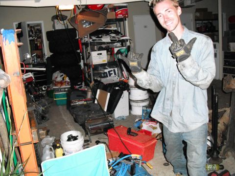 1991 Ford Bronco - A man stands in a cluttered garage, holding up his middle finger.