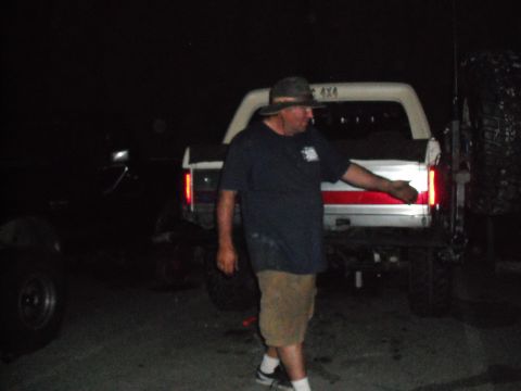 1991 Ford Bronco - A man stands by the rear of a 1991 Ford Bronco, which has a white body and a red stripe along the tailgate.