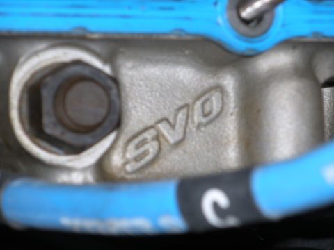 1995 Ford Bronco - Close-up of an engine component showing the 'SVO' designation, with a blue gasket visible.