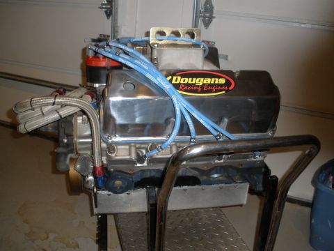 1995 Ford Bronco - A chrome engine with blue spark plug wires and a "Dougan's Racing Engines" sticker is mounted on a stand.