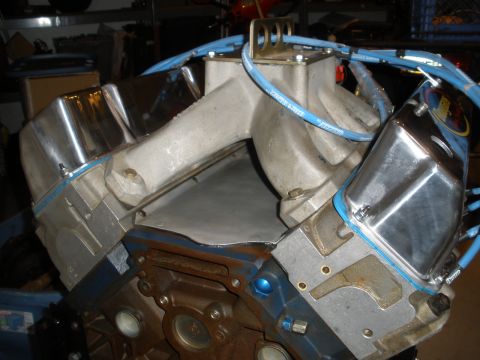 1995 Ford Bronco - Close-up view of an engine block with chrome valve covers and blue spark plug wires.