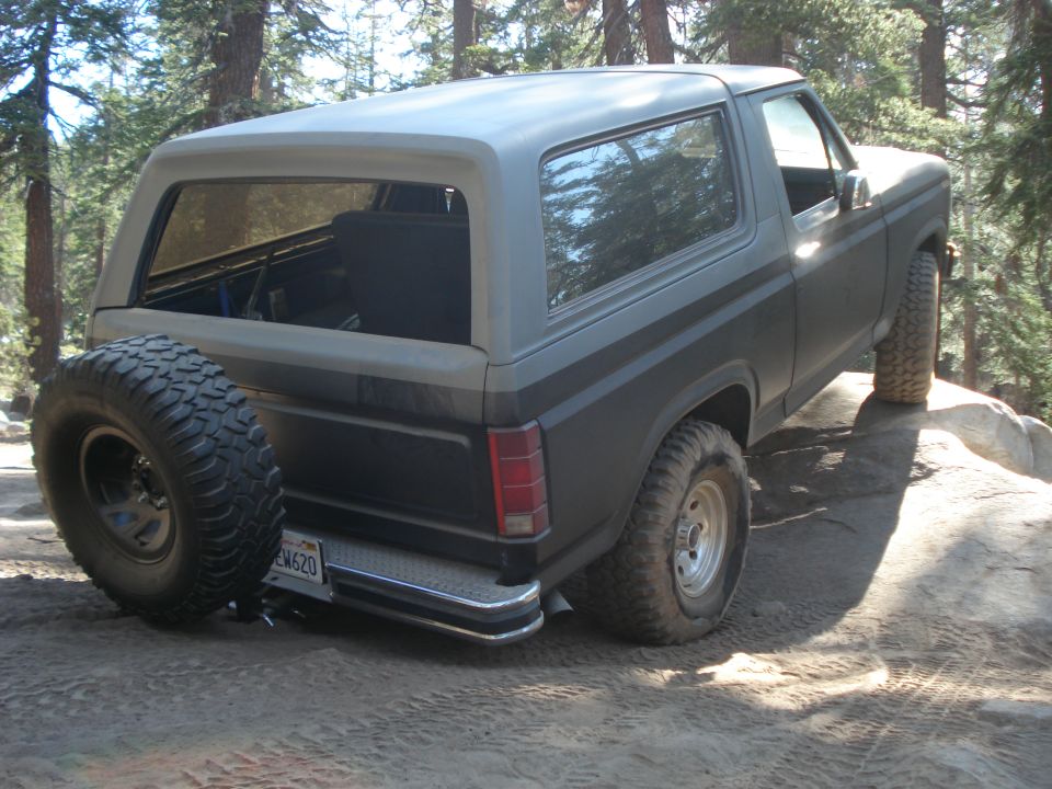 Ford Bronco on rocky terrain, spare tire mounted on rear door. License plate reads EW620