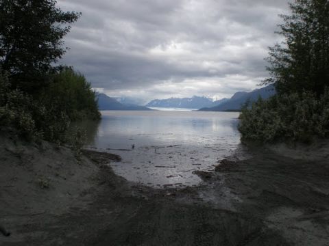 1987 Suzuki Samurai - A view of a calm body of water with mountains in the distance under a cloudy sky.