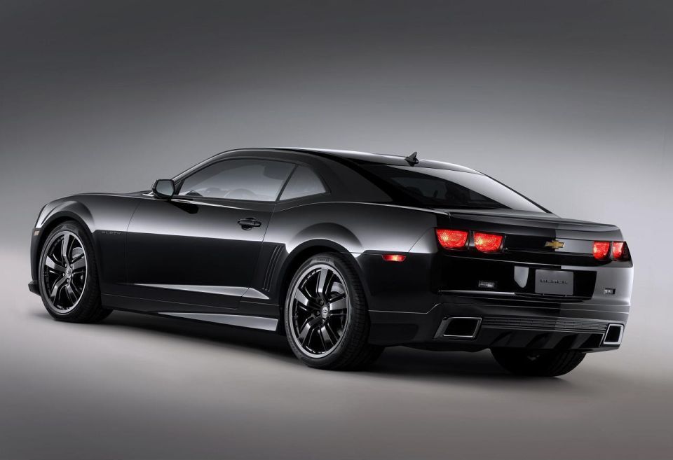 Black coupe, rear 3/4 view, with aftermarket wheels and body kit