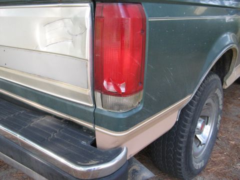 1989 Ford Bronco - The rear quarter panel and taillight assembly of a Ford F-Series truck are visible, with damage to the body and light.