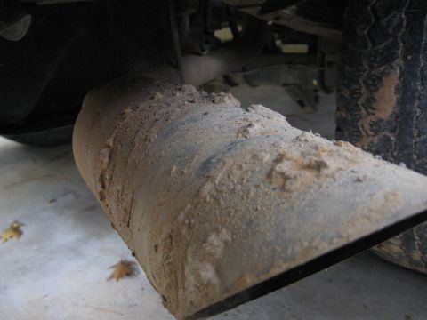 1989 Ford Bronco - The exhaust pipe is covered in dirt and grime, suggesting recent off-road use.