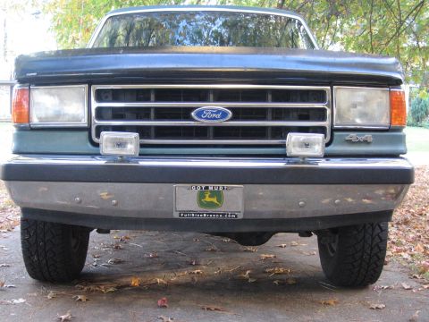 1989 Ford Bronco - Front view of a green Ford Bronco with a chrome bumper and "4x4" badging.