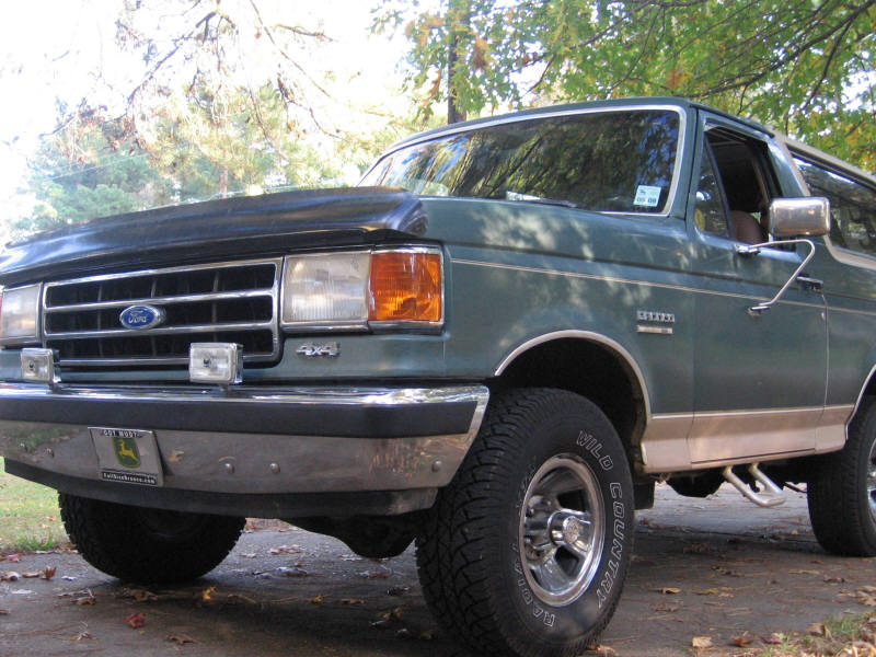 Green 1989 Ford Bronco 3q-front view with chrome bumper and "4x4" badge