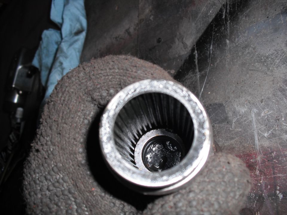 Splined shaft inside a metal housing, held by a gloved hand