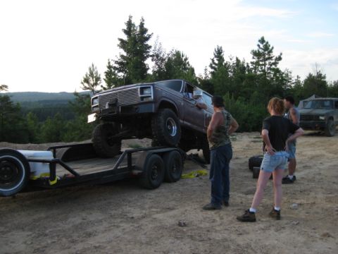 1980 Ford Bronco - 1980 Ford Bronco on a trailer with people watching; another SUV is parked nearby.