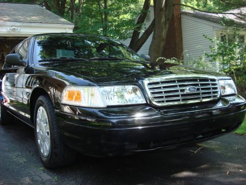 2006 Ford Crown Victoria - Front view of a black 2006 Ford Crown Victoria, its chrome grille and headlights.