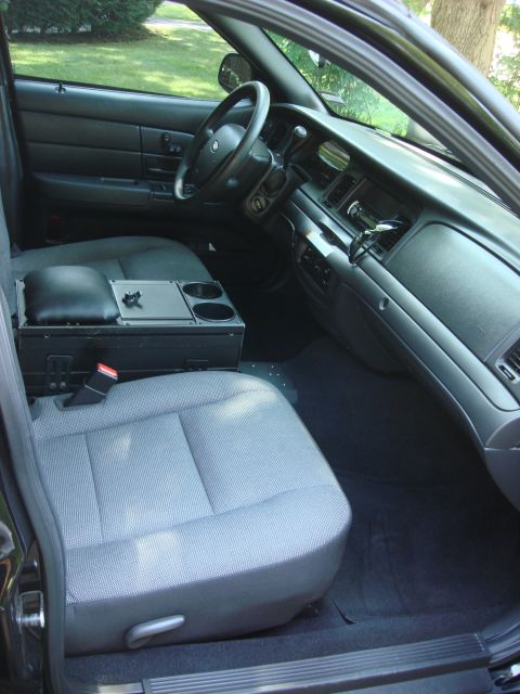 2006 Ford Crown Victoria - The interior of a police car is shown, the front seats and dashboard area.