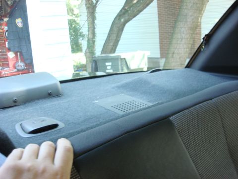 2006 Ford Crown Victoria - View of the rear interior deck of a vehicle, showing the speaker grille and a grab handle.