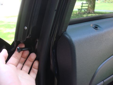 2006 Ford Crown Victoria - Close-up of a vehicle's interior door latch mechanism being operated by a hand.