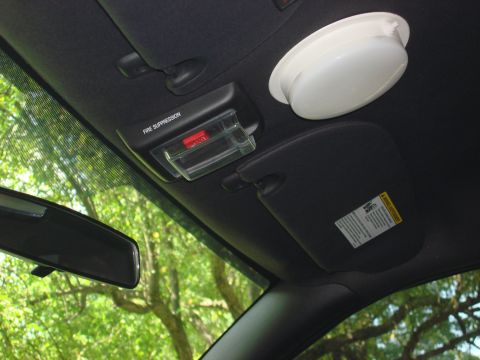 2006 Ford Crown Victoria - The interior ceiling of a vehicle shows a rearview mirror, sun visor, and a fire suppression system.