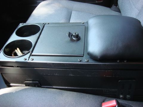 2006 Ford Crown Victoria - Interior view of a vehicle's center console, cup holders and an armrest.