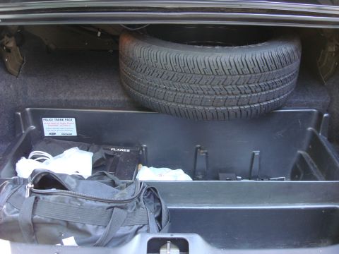 2006 Ford Crown Victoria - The trunk contains a spare tire, a duffel bag, and a police trunk pack with flares and other emergency supplies.