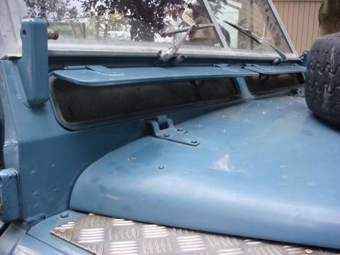 1972 Land Rover Land Rover - The front of a blue 1972 Land Rover Land Rover is shown from a close-up angle, highlighting the hood and windshield area.