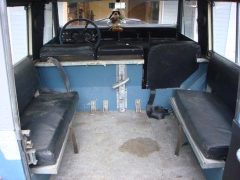 1972 Land Rover Land Rover - The interior of a 1972 Land Rover shows its utilitarian design with bench seating and blue paneling.
