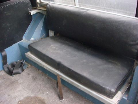 1972 Land Rover Land Rover - Interior view of a vehicle's rear seating area, showing black vinyl seats and blue painted metal panels.