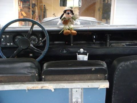 1972 Land Rover Land Rover - The interior of a 1972 Land Rover Land Rover features a distinctive blue steering wheel and a dashboard adorned with a safari-themed plush…