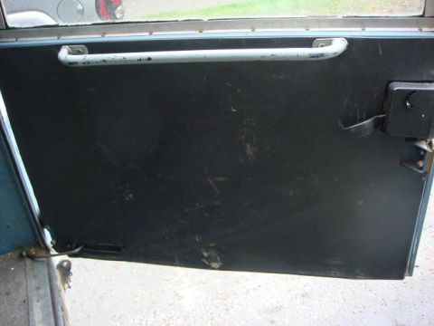 1972 Land Rover Land Rover - Close-up of a vehicle's interior door panel, showing wear and tear on the surface.