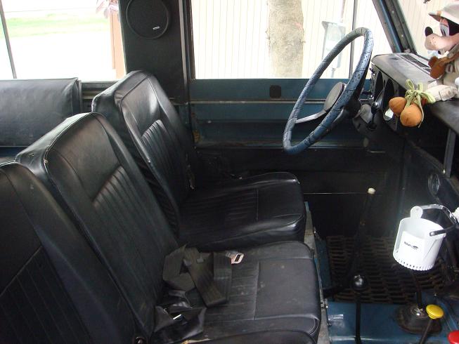 Interior view of a blue vehicle showing front seats, dashboard, and steering wheel