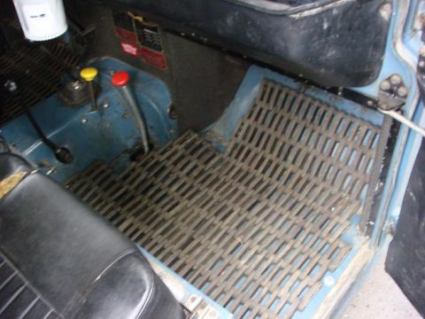 1972 Land Rover Land Rover - The interior of the vehicle features a metal grid floor mat and two prominent gear shift levers.