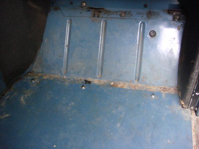 Blue interior floor panel with raised ribs and visible rust