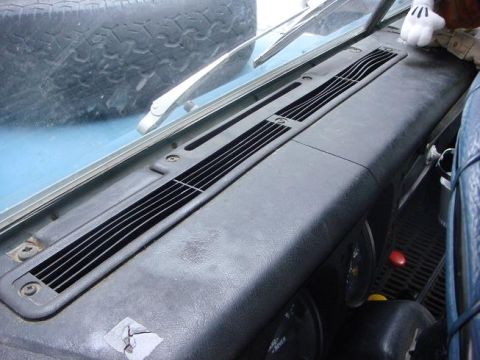 1972 Land Rover Land Rover - Close-up of the dashboard vents and windshield wipers, with a spare tire visible through the windshield.