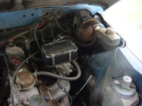 1972 Land Rover Land Rover - The engine bay of a vehicle, an aftermarket air filter and brake booster, with various hoses and wiring visible.