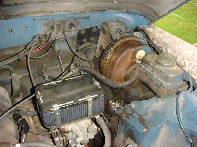 1972 Land Rover Land Rover engine bay with blue paint, aftermarket air filter, and brake booster