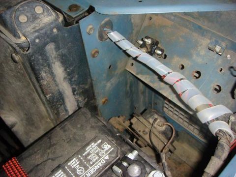 1972 Land Rover Land Rover - Close-up view of the engine bay, showing the battery and a wrapped wiring harness.